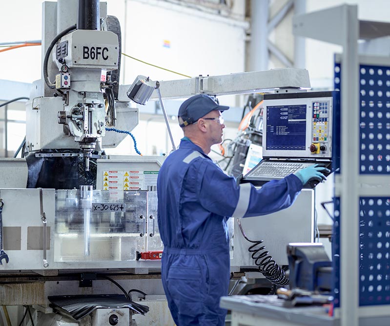 Opérateur usinant une pièce dans une usine industrielle